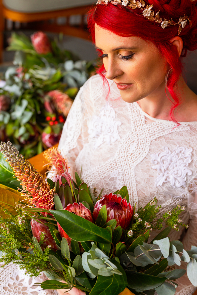 A bride and her native floral bouquet sitting whilst taking her portrait photos on her wedding day at Ridge Estate