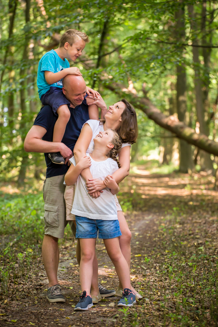 Central Coast family portrait photographer, family standing in the woods, laughing,looking at each other.